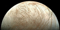Europa, moon of Jupiter, is thought to hide a sea of liquid water beneath its icy surface. Could an extraterrestrial ecosystem thrive in this dark alien ocean? © NASA