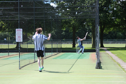 Colour photo of students in sports kit at the cricket nets