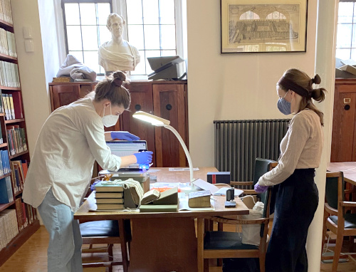 Photograph of researcher and conservator analysing a manuscript.