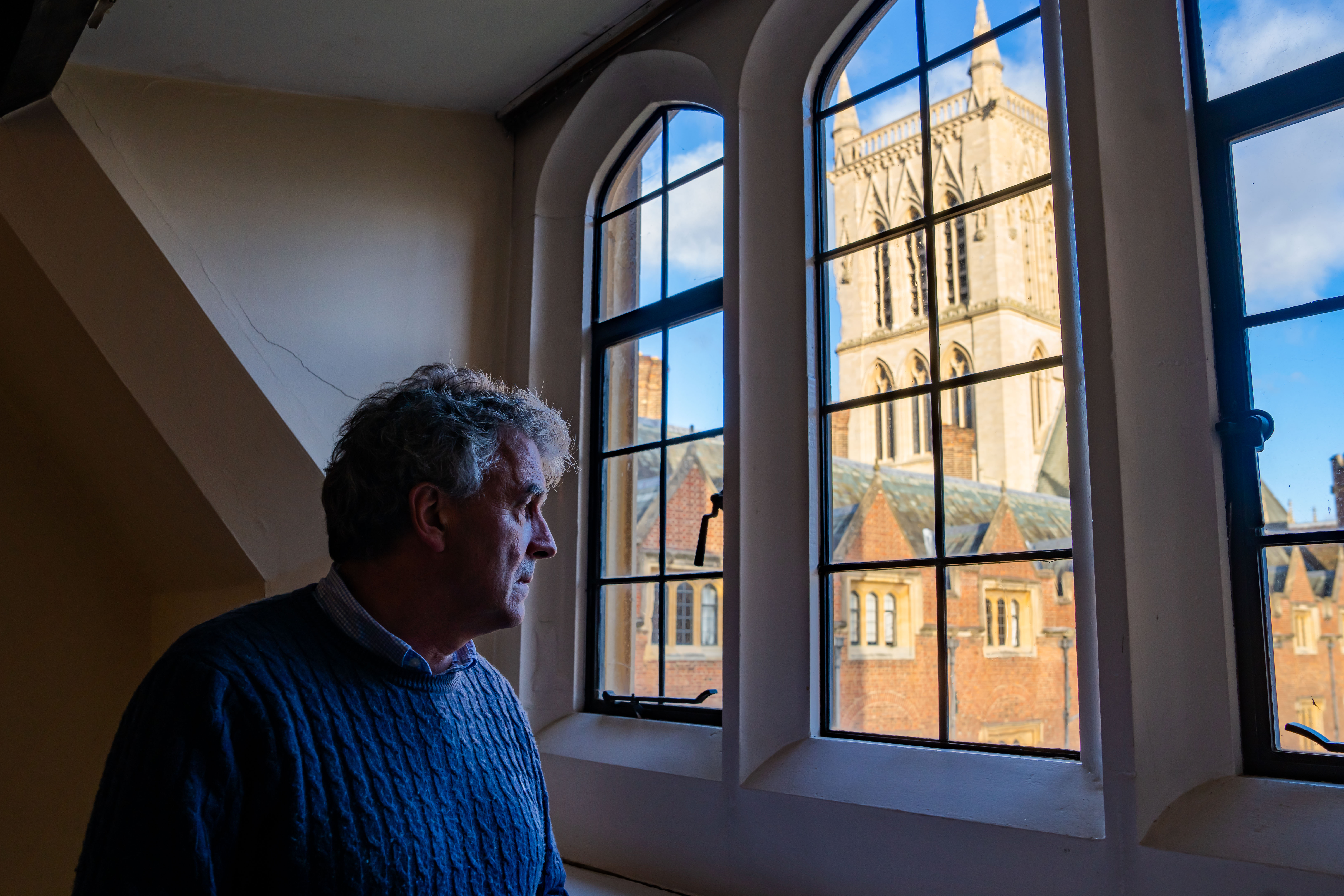 Prof Andy Woods looking out of a College window