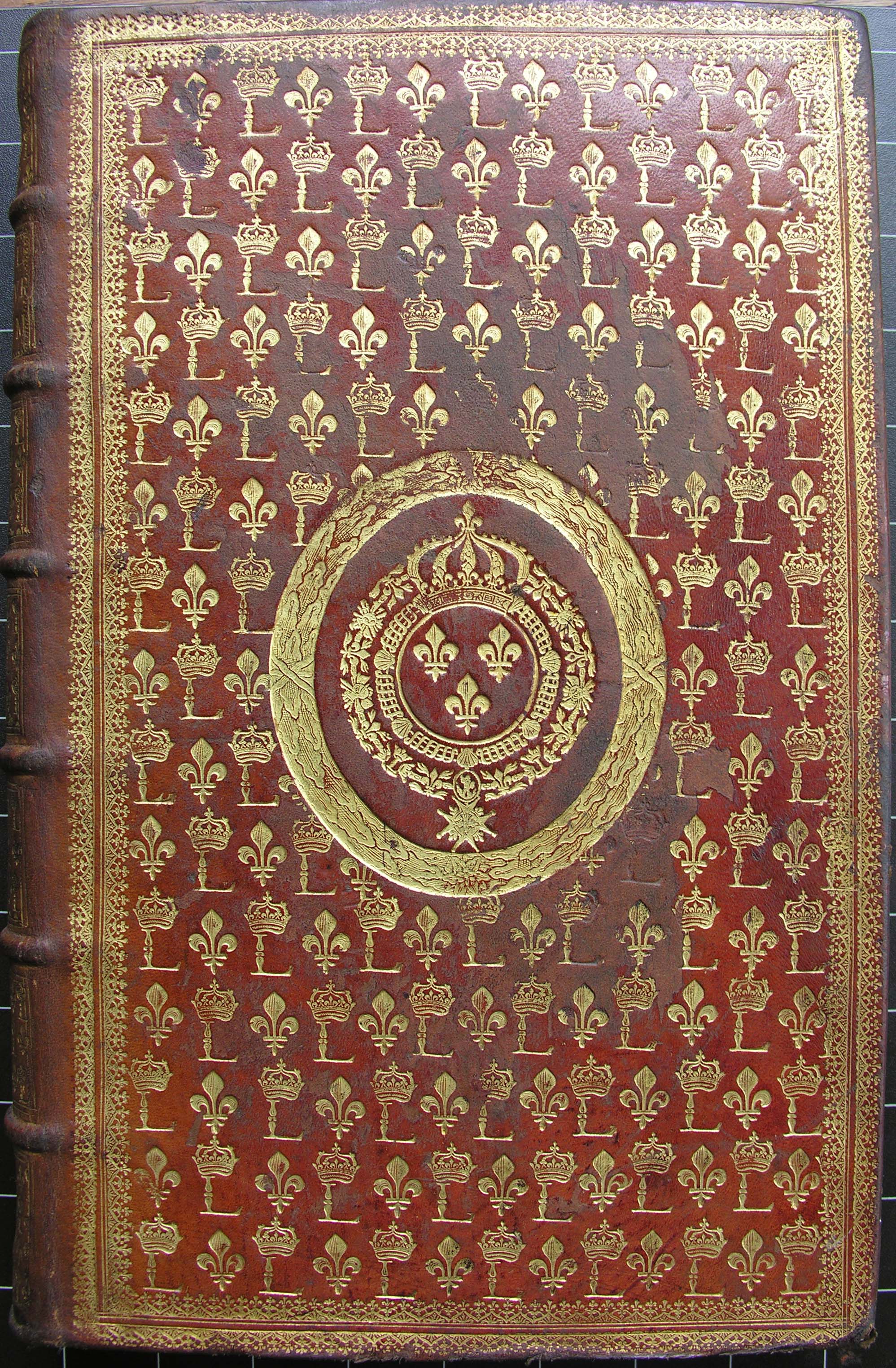 An elaborate red and gold binding covered in fleur de lys.