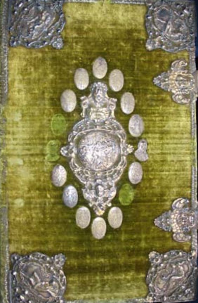 A huge book bound in green velvet with ornamental silver plates on the cover.