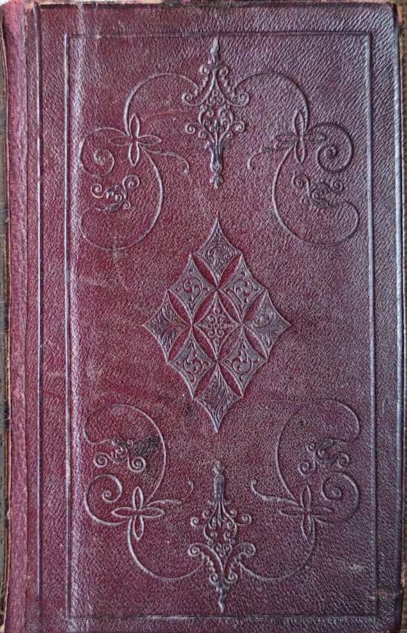 The front cover of a book bound in red leather.
