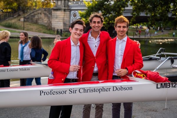 Ryan Geiser, centre, with a new boat named in honour of Ryan’s mentor and supervisor, Professor Sir Christopher Dobson. 