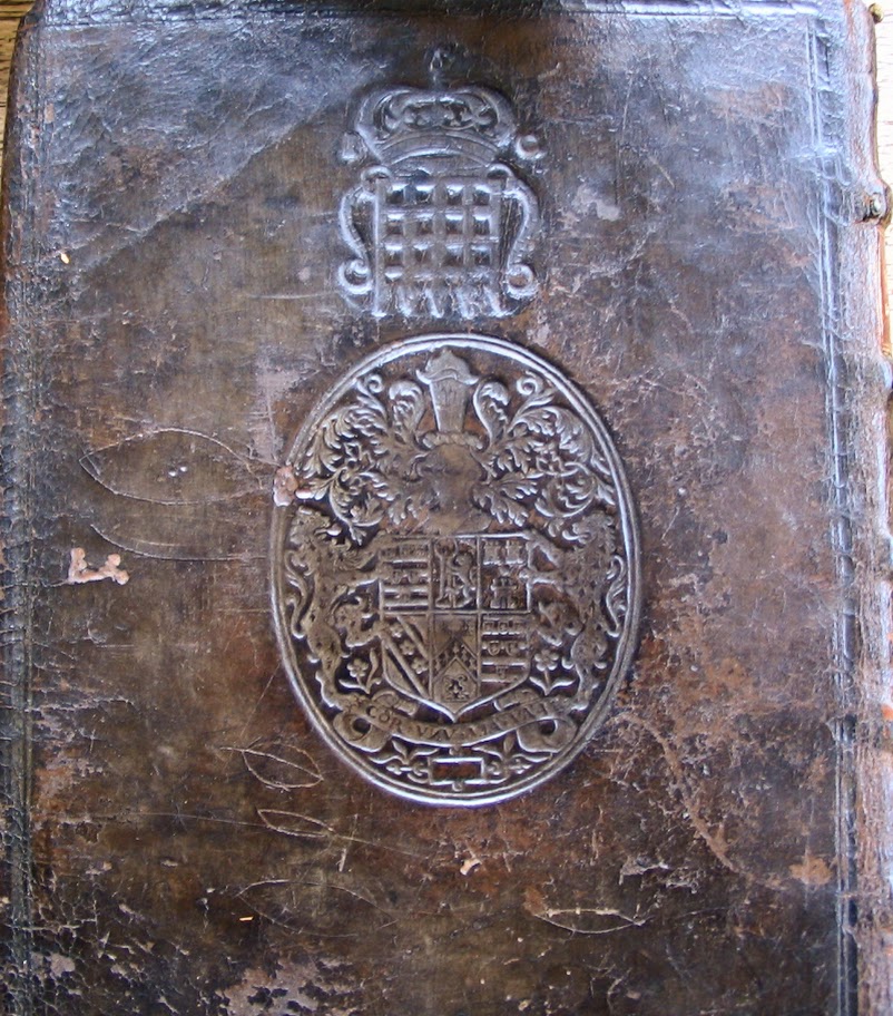 A book bound in dark brown leather, embossed with a coat of arms.