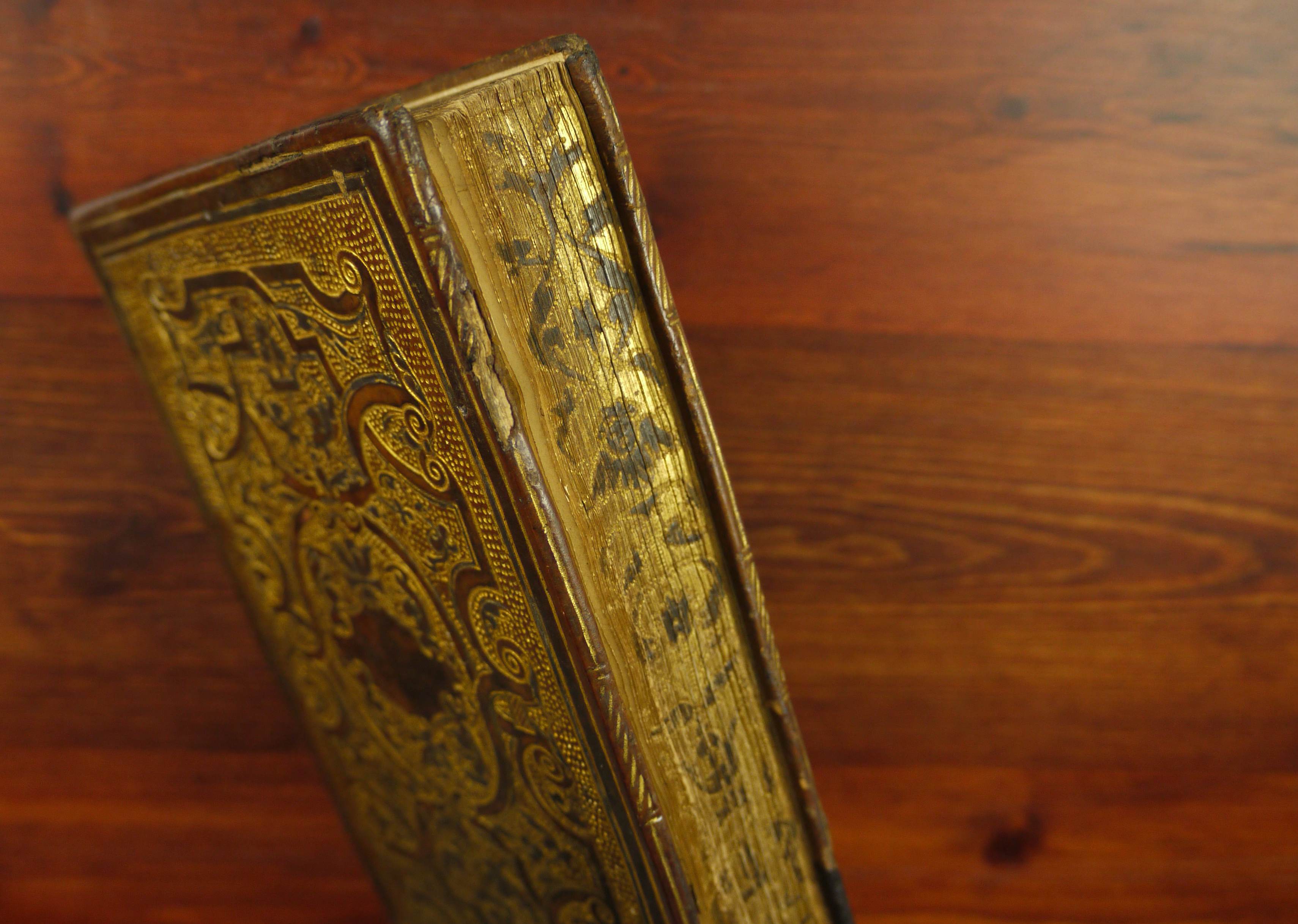 A side view of a very ornate book decorated with gold.
