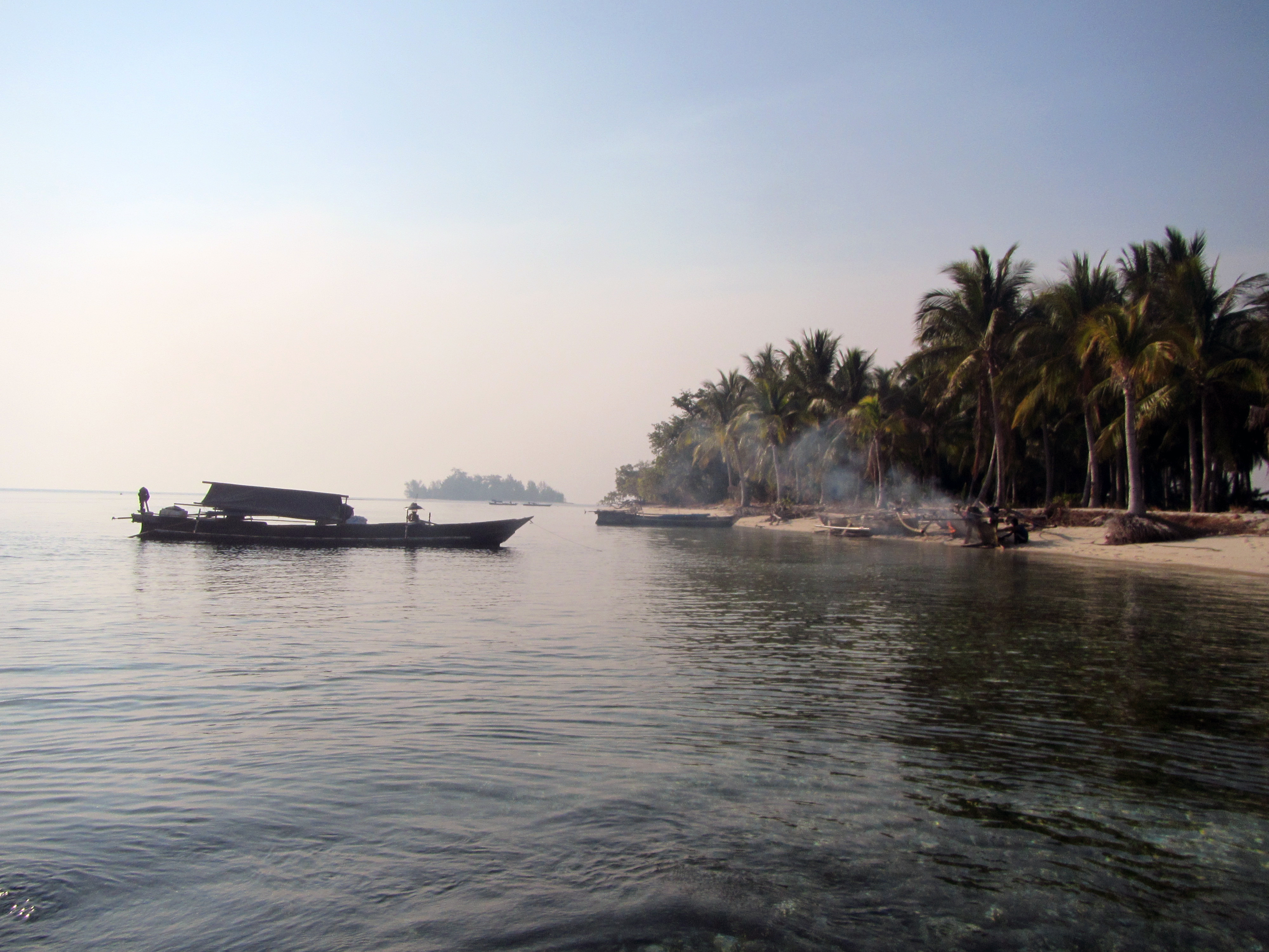 A small, unnamed island serves as a haven for visiting Bajau houseboats.