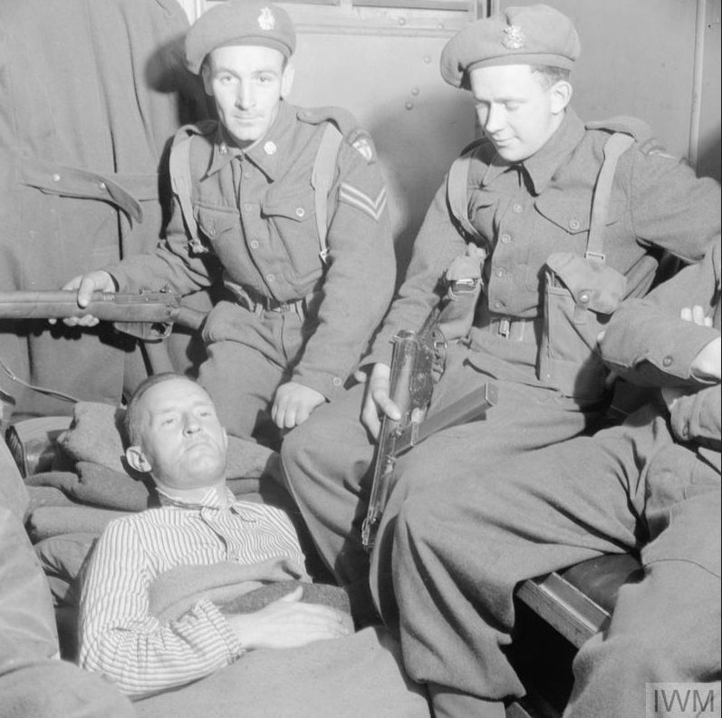 William Joyce, known as Lord Haw-Haw, lays in an ambulance surrounded by armed guards after being shot while being arrested in Germany in May 1945