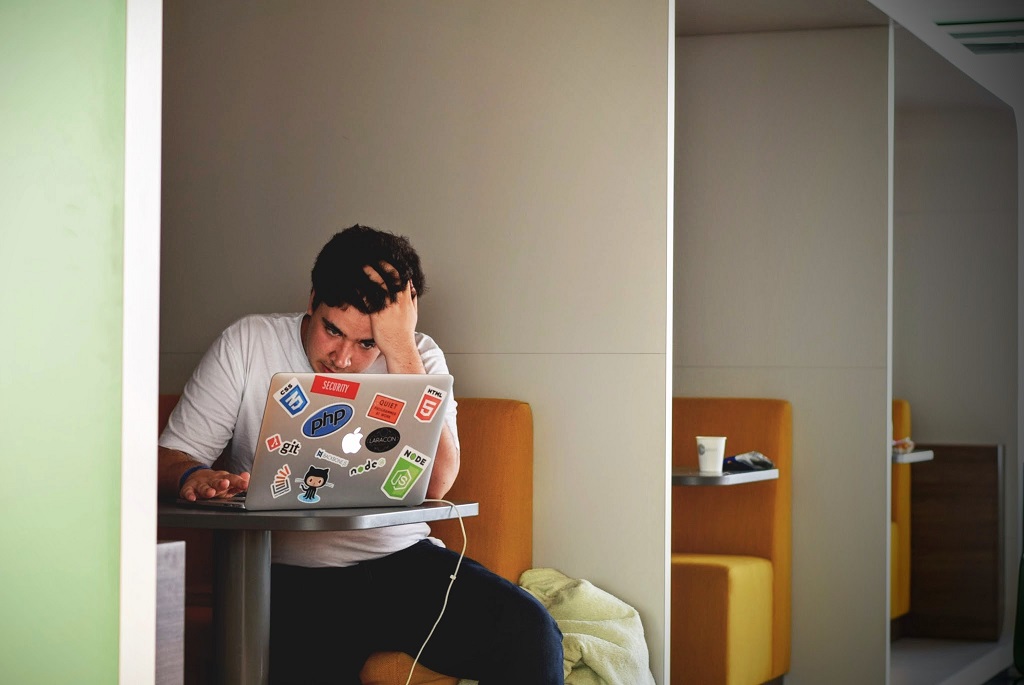 Student sits at a table looking stressed